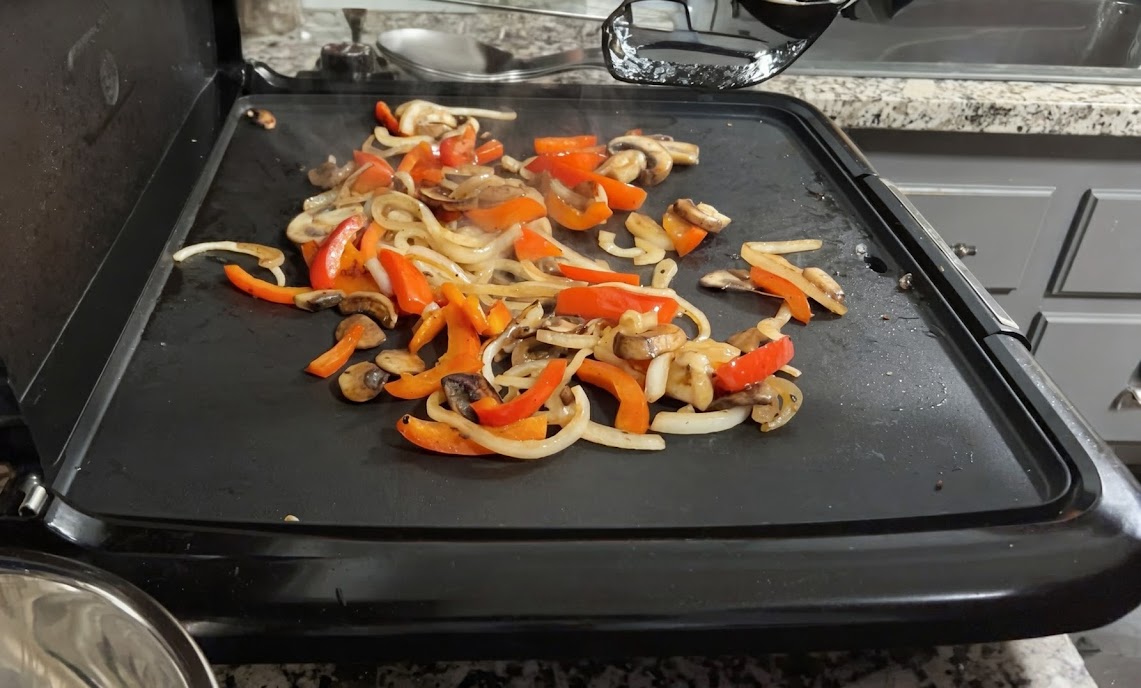Peppers, onions, and mushrooms on the griddle