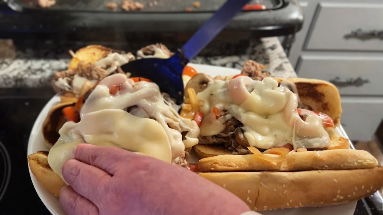 Finished Philly cheesesteak tucked into a hoagie