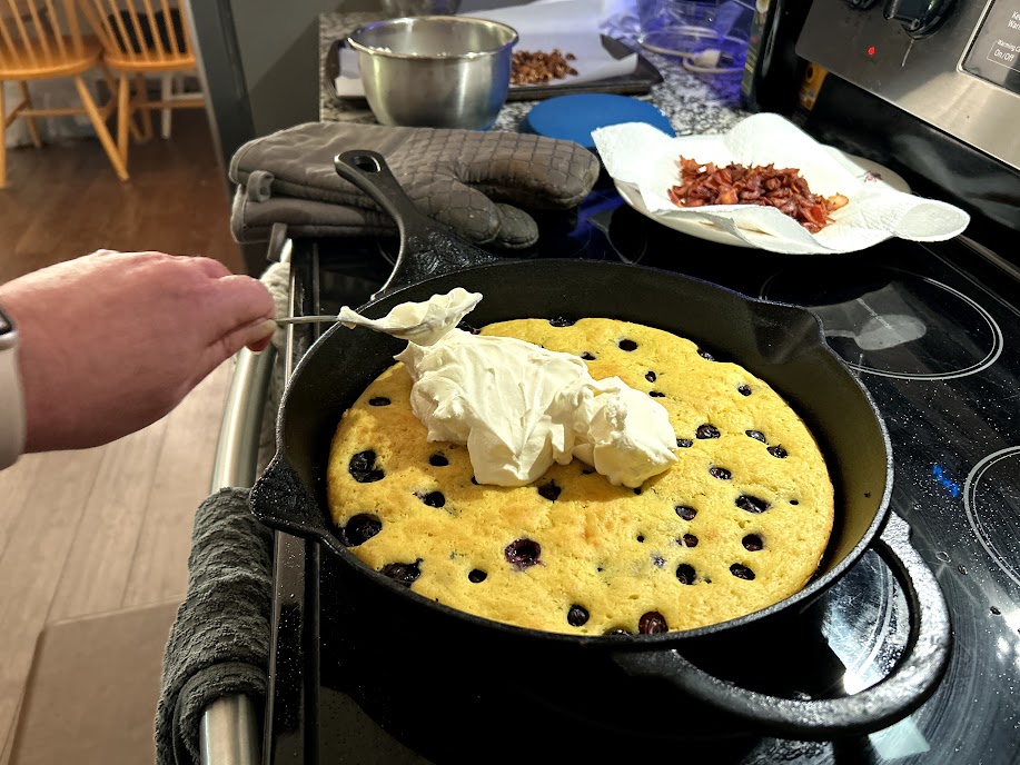 Spreading mascarpone on pancake pizza